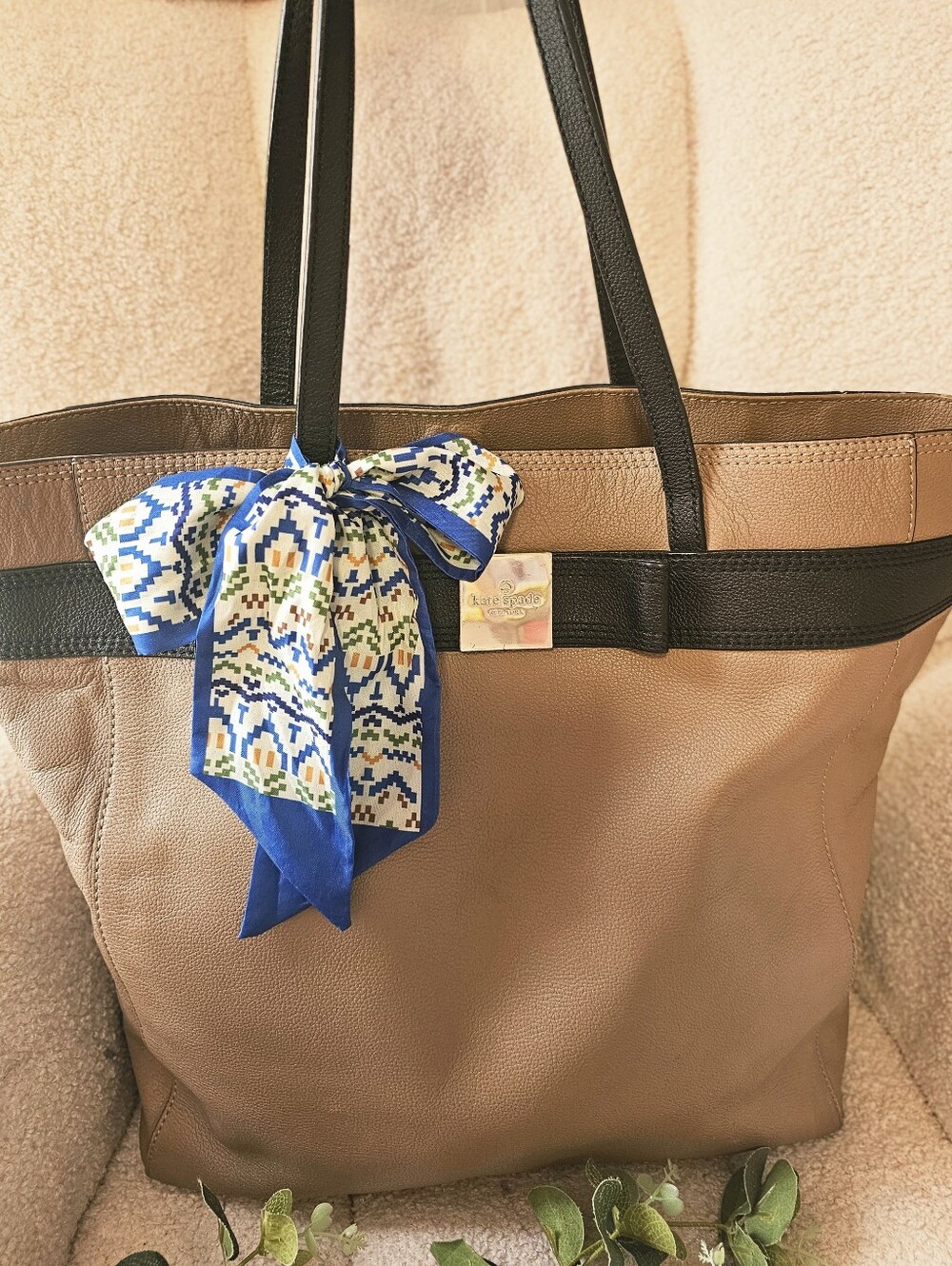 kate spade brown tote with black trim and blue patterned scarf